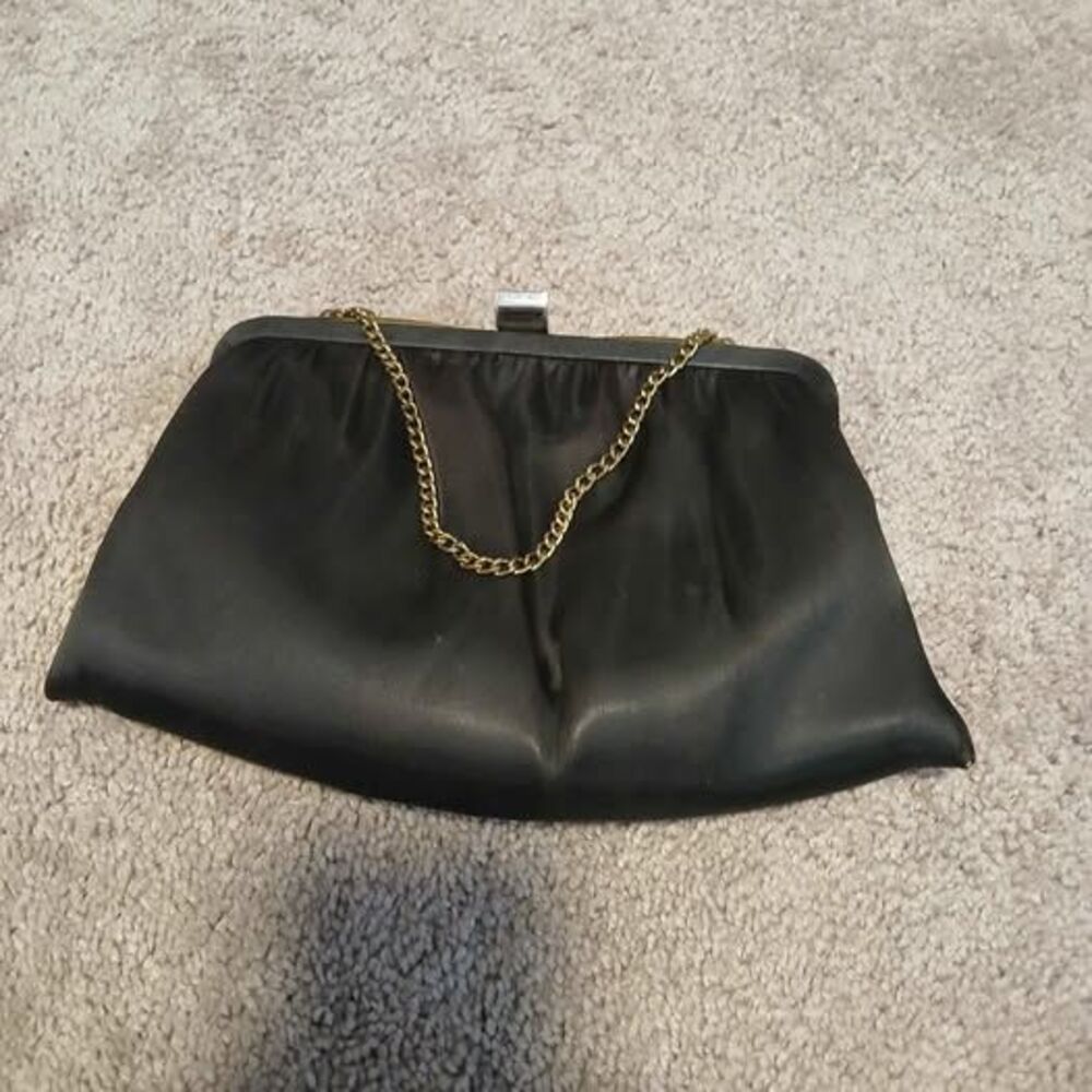 vintage clutch purse made of black satin with a gold tone chain handle.